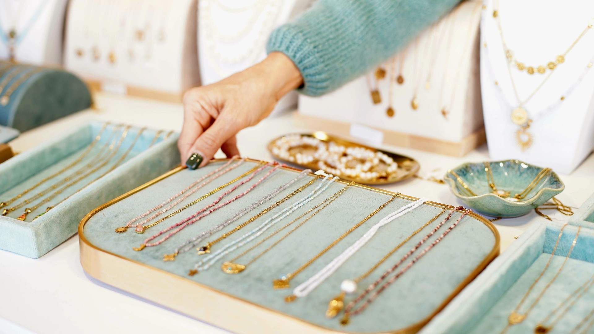 Bracelets and chains on the counter. Silver and other metal jewelry. Products with and without stones. Closeup.  Soft focus